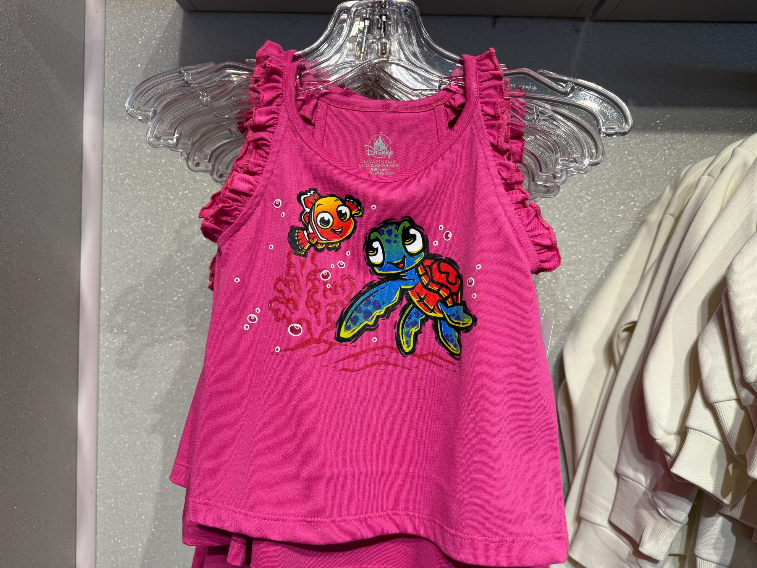 ピンクのフリル付きタンクトップにニモとスクワートがデザイン