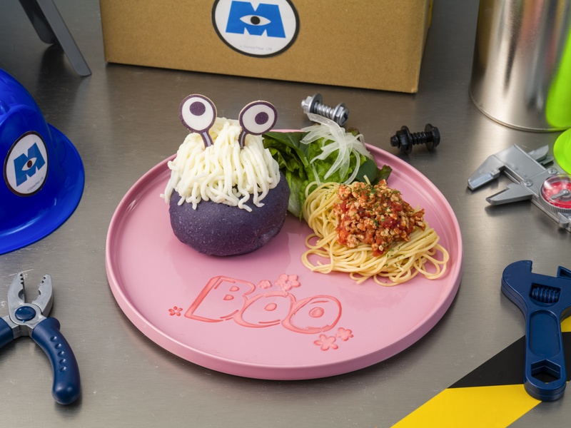 紫色のモンスターの着ぐるみを模した料理とミートソースパスタがピンクのプレートに盛り付けられている