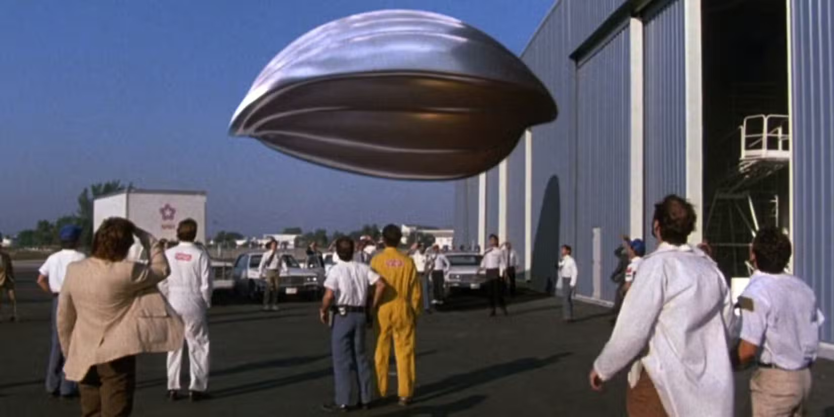 空飛ぶ宇宙船を見上げる人々のシーン