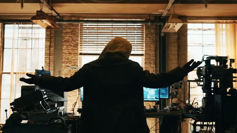 フードを被った謎の人物の後ろ姿
