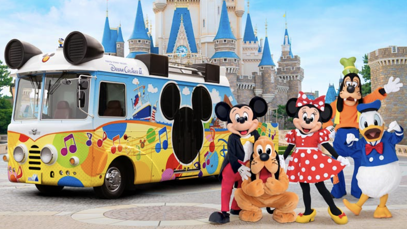 カラフルなディズニーバスとミッキー、ミニー、グーフィー、プルート、ドナルドダックが並んで写っている公式画像