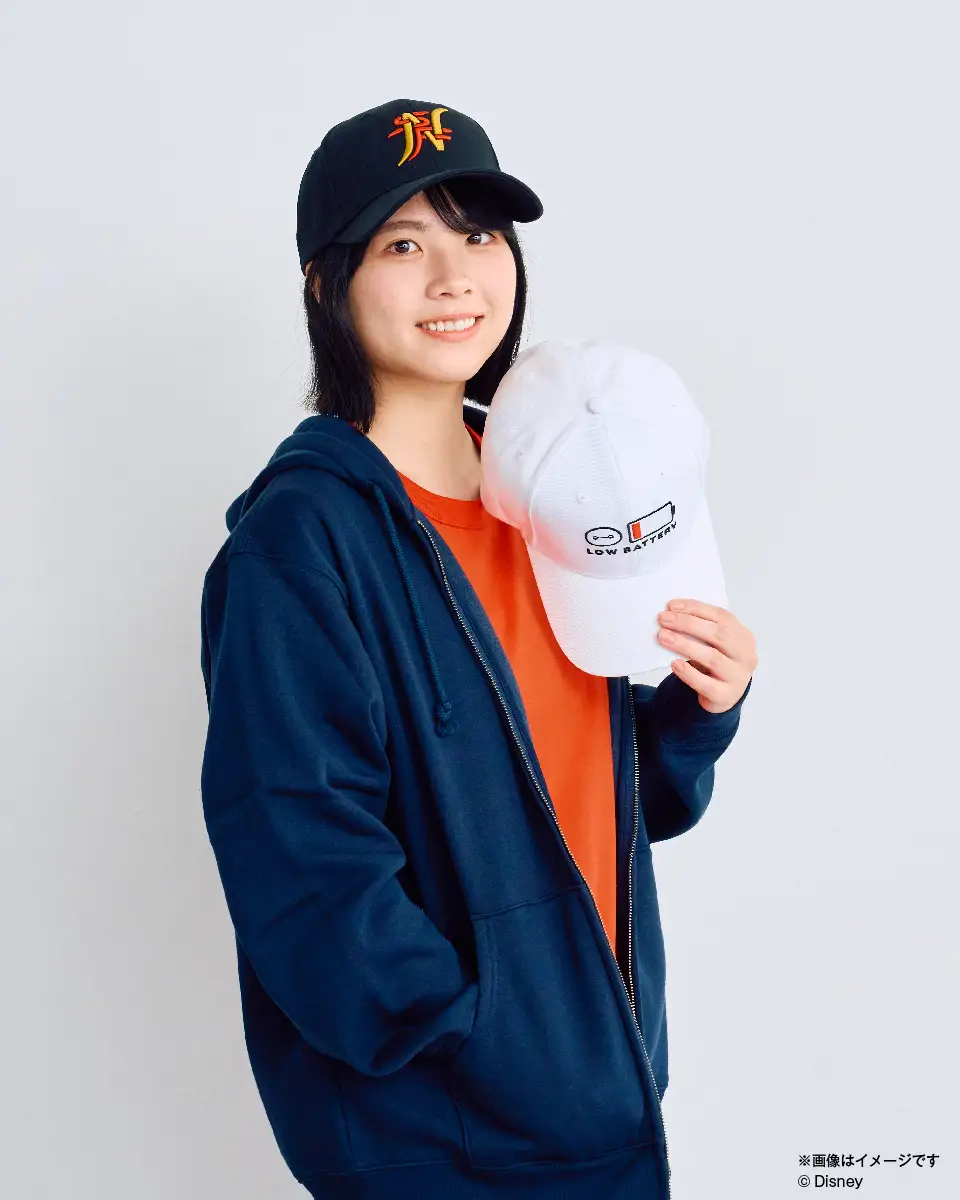 シースルーブルゾンとキャップを身に着けた女性