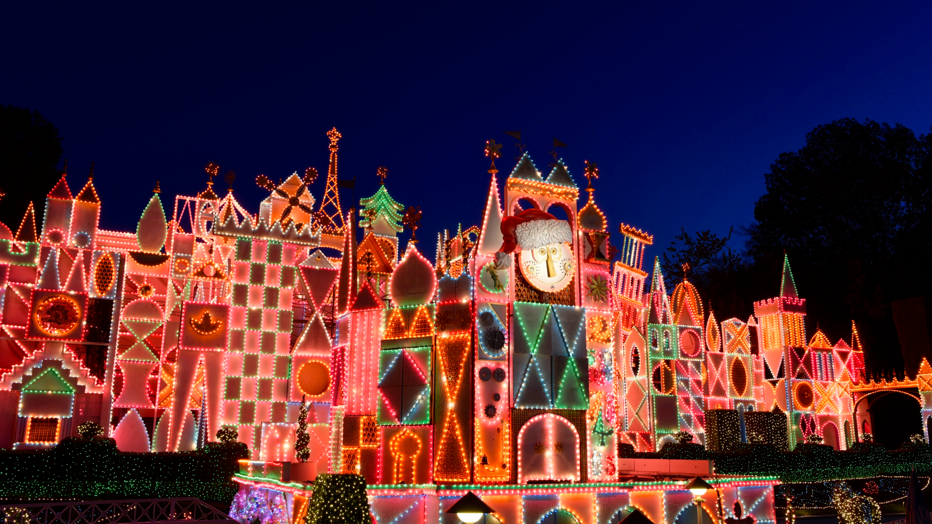 ホリデーライトに彩られたイッツ・ア・スモールワールドのファサード夜景