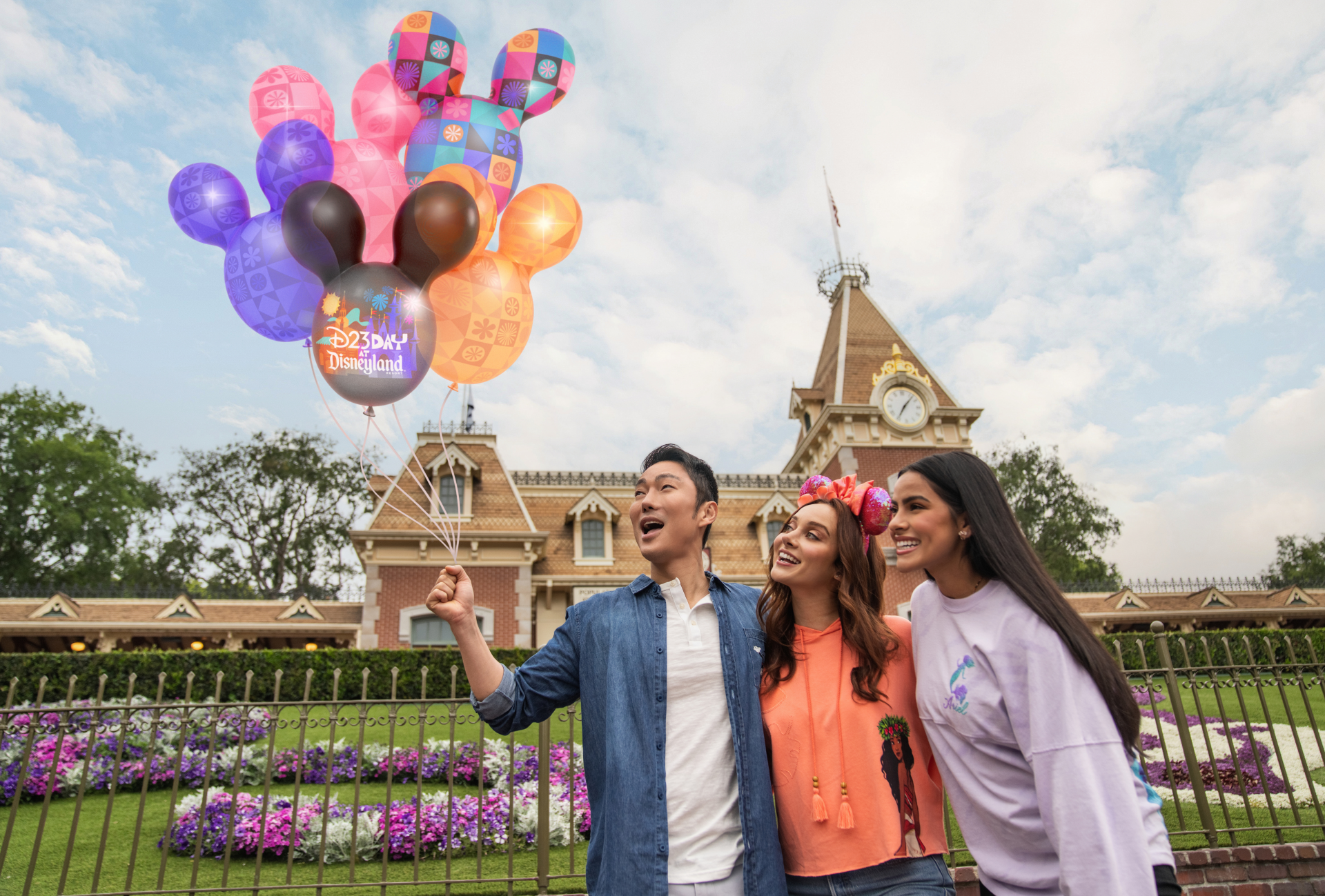 ディズニーランド正面ゲート前でD23デイ限定ミッキーバルーンを持つゲストたち