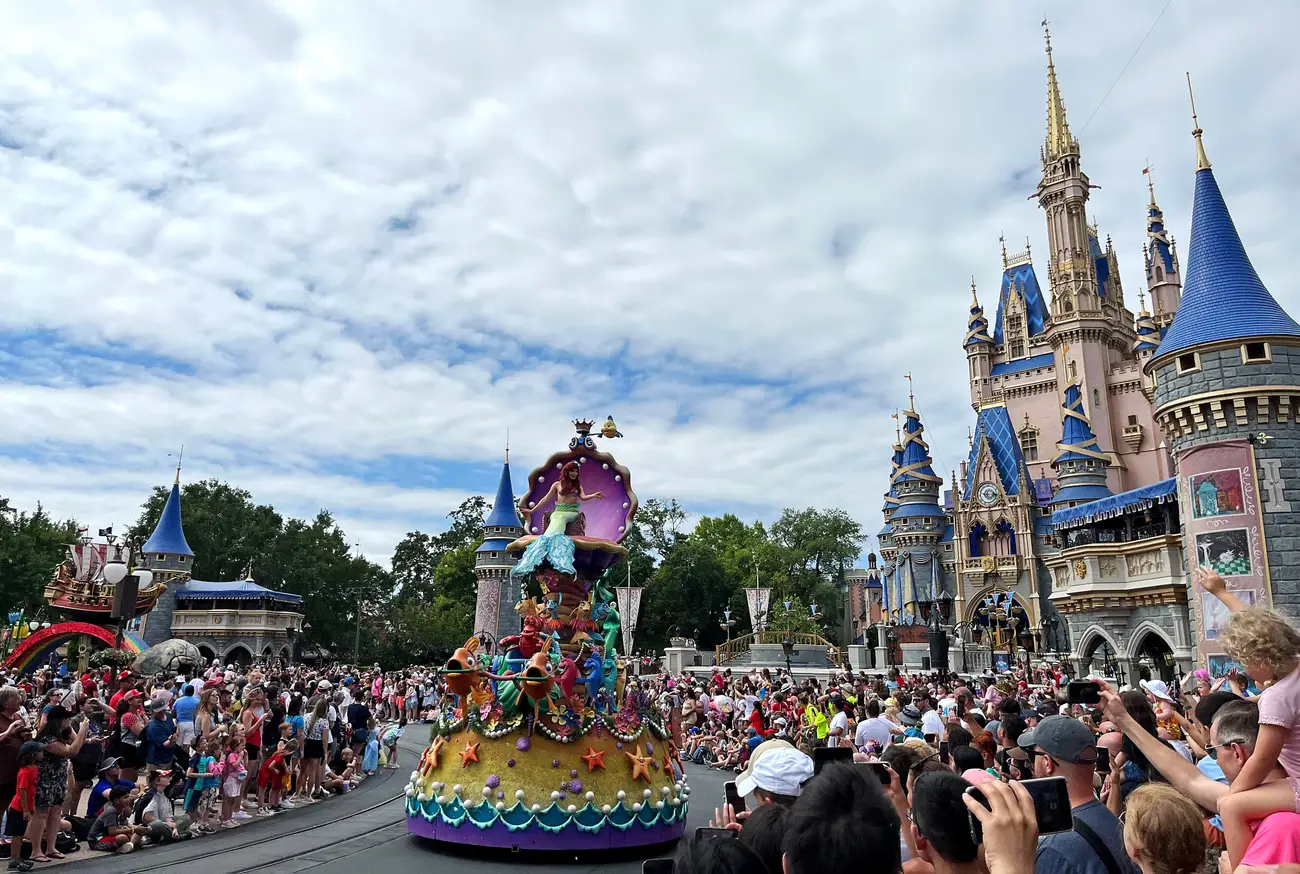 シンデレラ城前を行進するディズニーパレードのアリエルフロートと大勢の観客