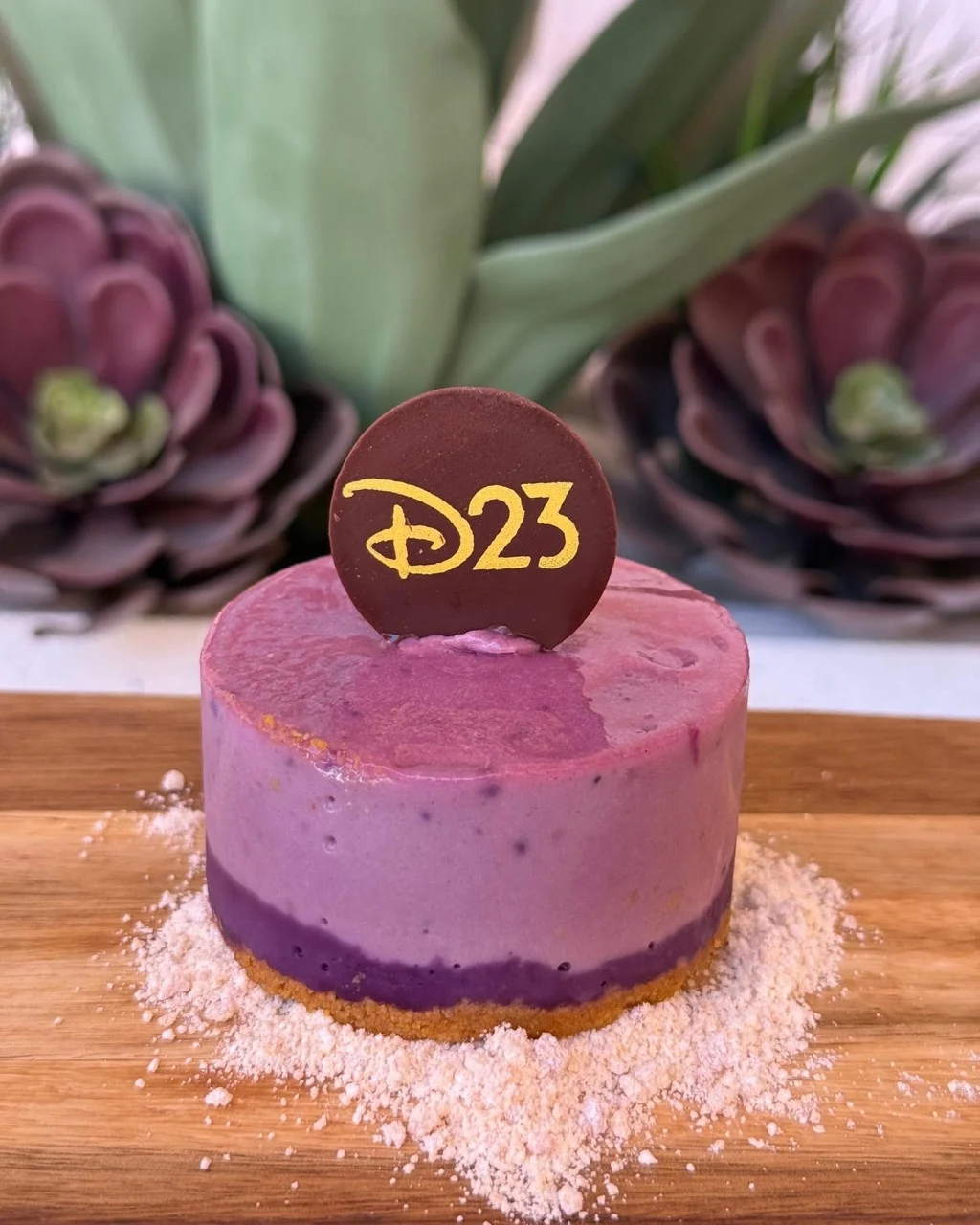 D23ロゴのチョコプレートを飾った紫色のウベ・ミニチーズケーキ