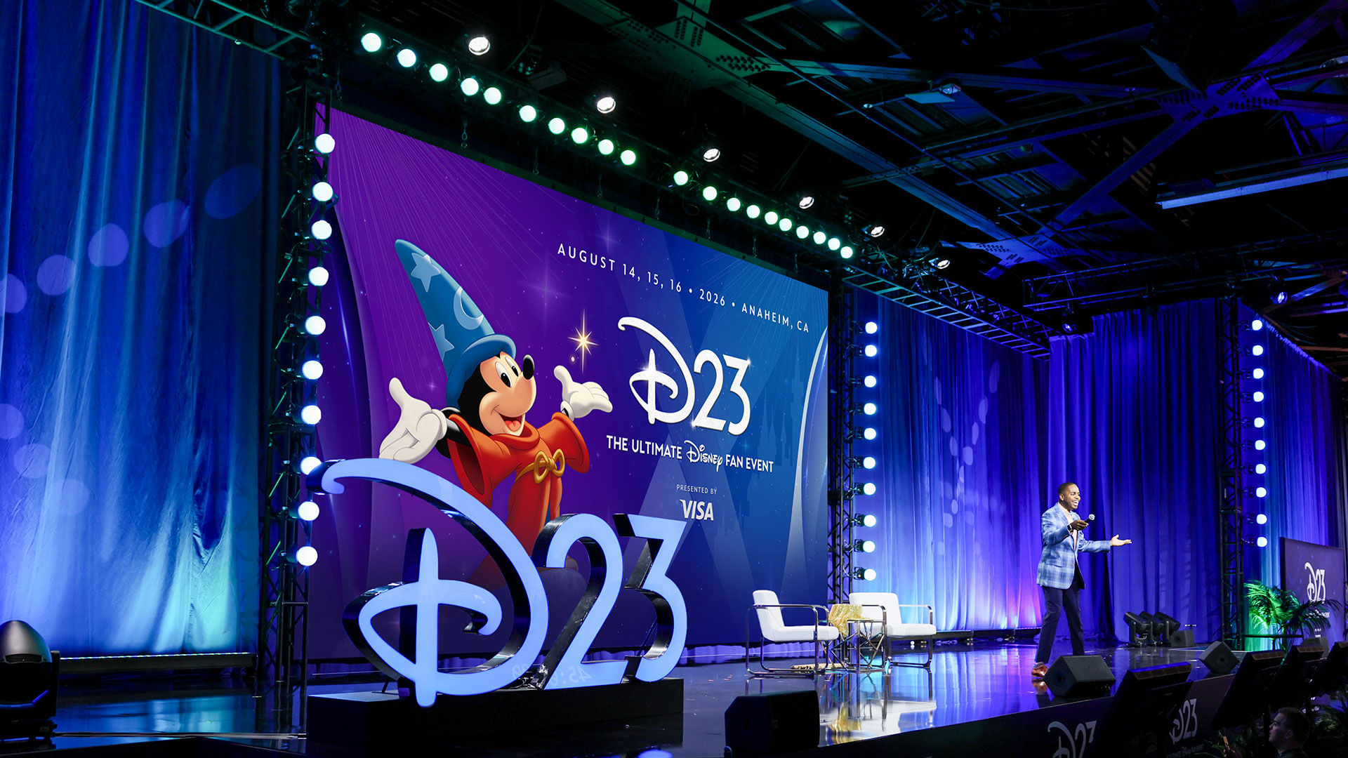 D23 The Ultimate Disney Fan Event 2026のステージ。ソーサラーミッキーの巨大オブジェと紫のバックスクリーンが印象的な会場全景