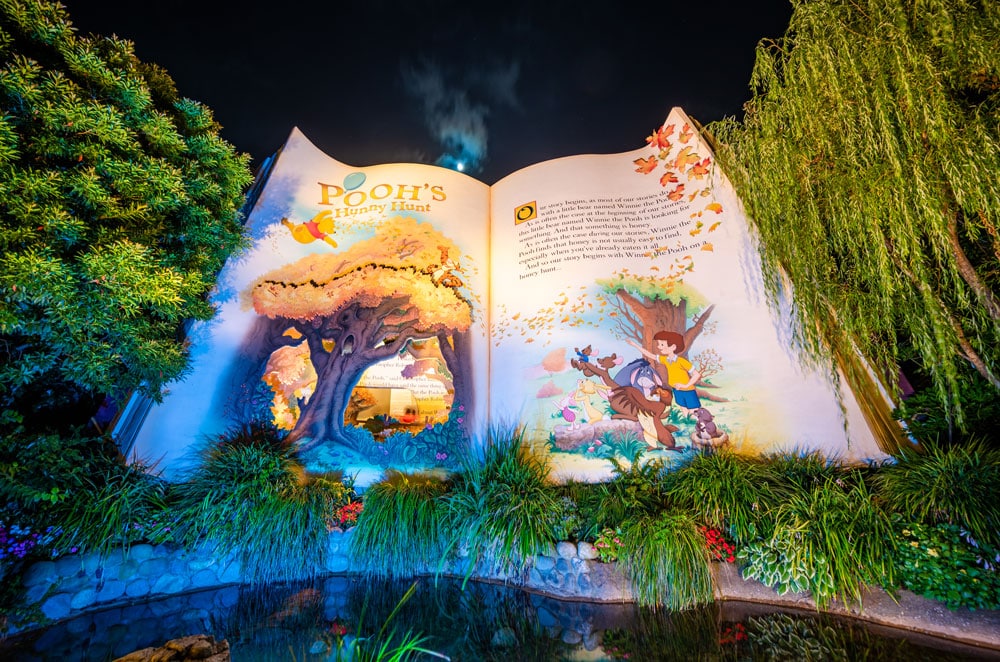 夜にライトアップされた東京ディズニーランドのプーさんのハニーハント入口の絵本型建物